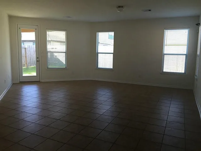 a view of an empty room with glass door and a window