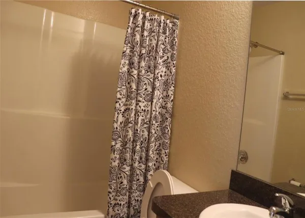 a bathroom with a toilet and shower curtain