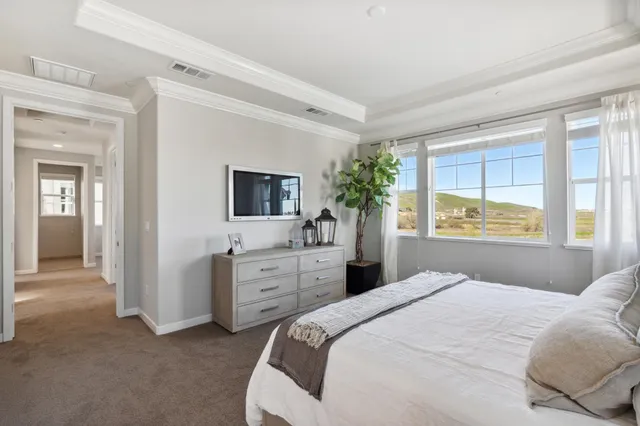 a bedroom with a bed and a potted plant on the dresser