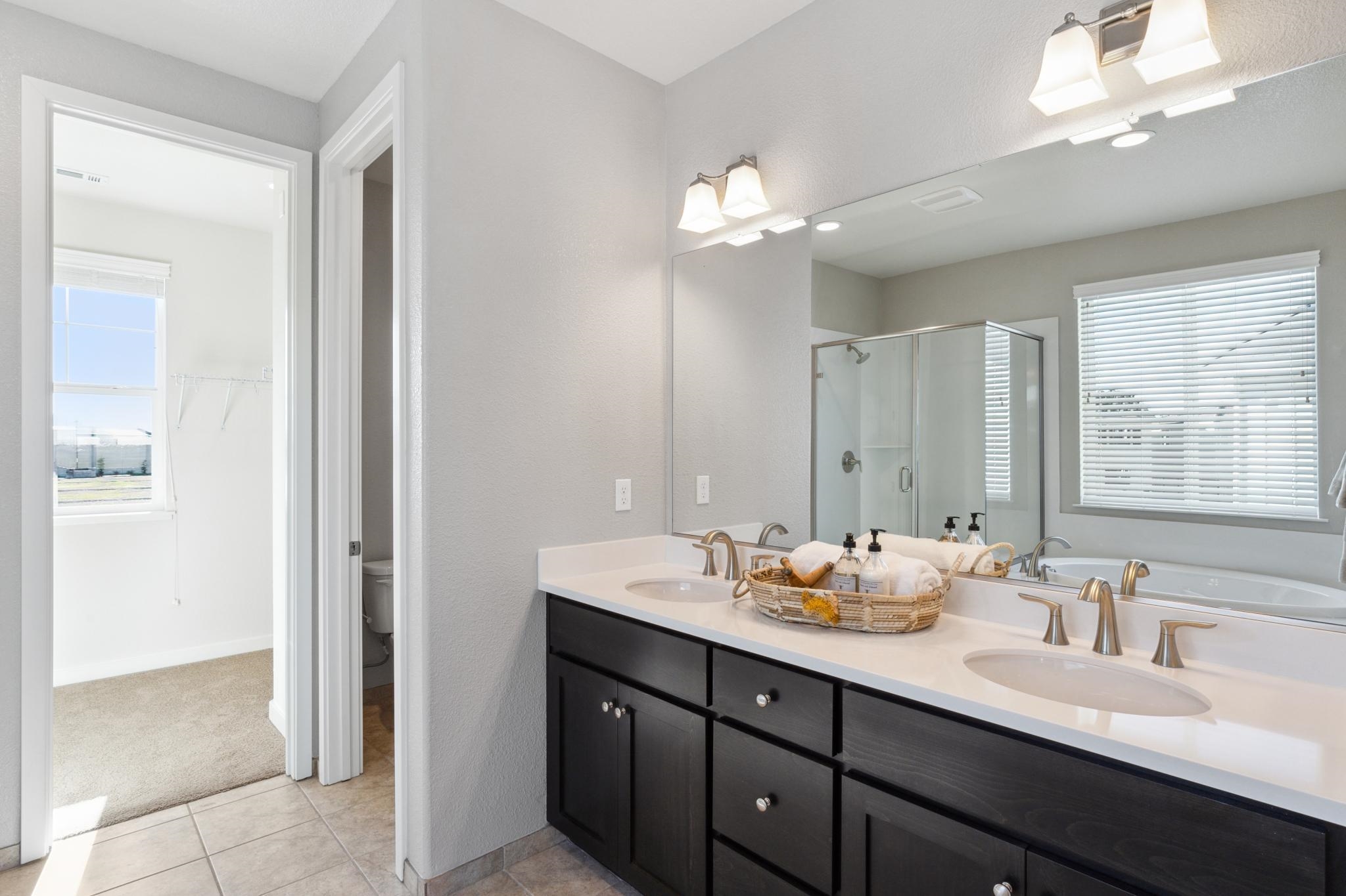 1476 Monument Lane Fairfield, CA 94533 - Photo 15 of 21 a bathroom with double vanity sinks a vanity a mirror and a shower
