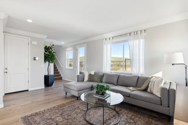 a living room with furniture kitchen view and a flat screen tv