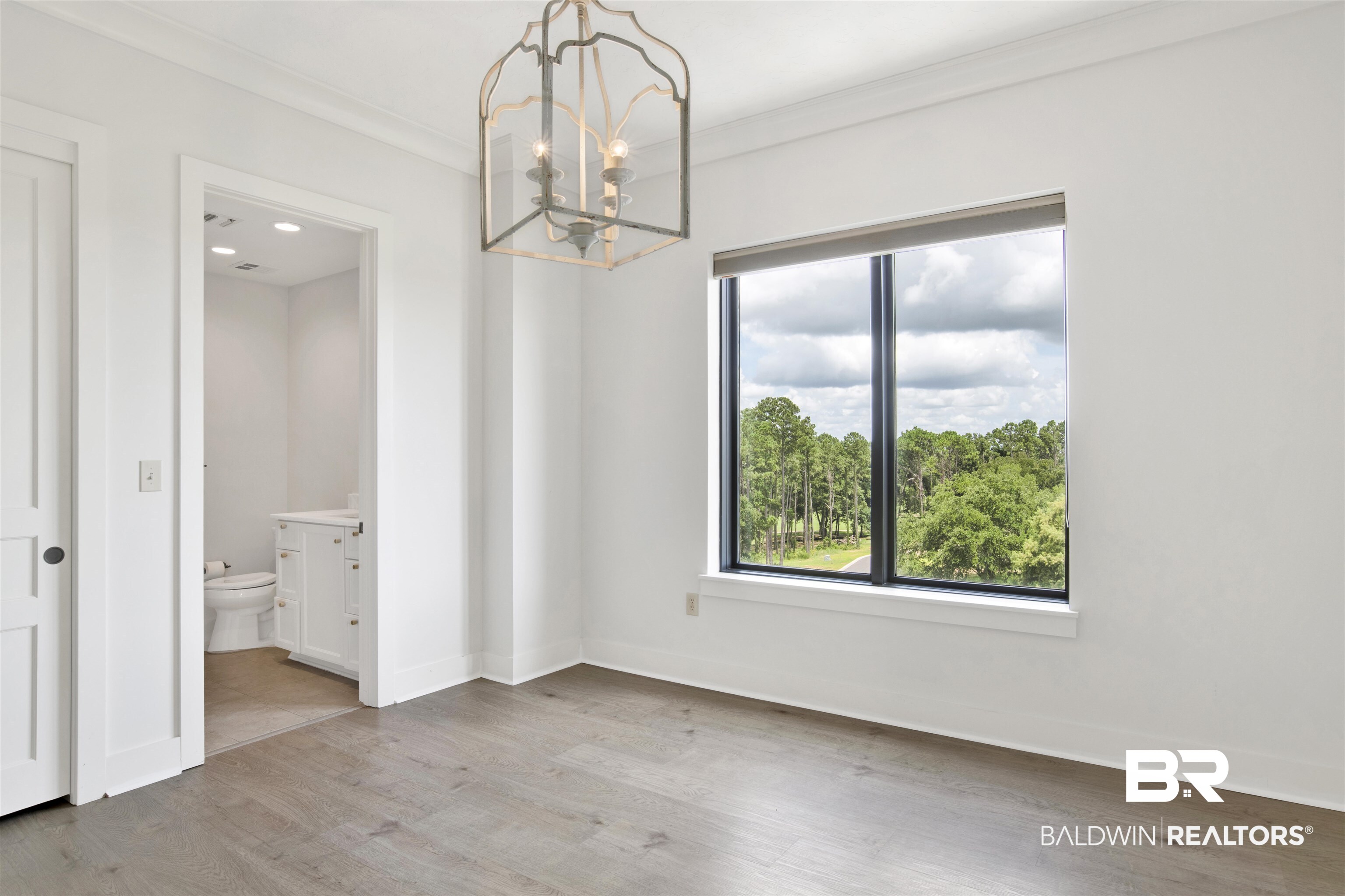18269 Colony Drive, Unit 601 Fairhope, AL 36532 - Photo 11 of 47 Unfurnished dining area with a notable chandelier, hardwood / wood-style flooring, and crown molding