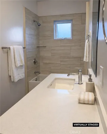 a bathroom with a tub sink and mirror