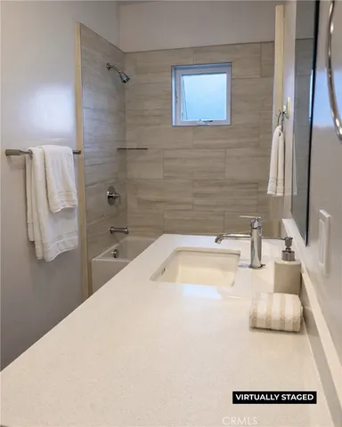 a bathroom with a tub sink and mirror
