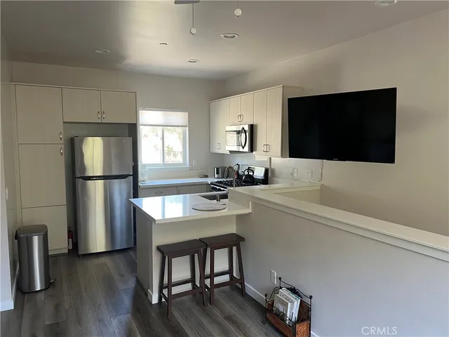 a kitchen with a refrigerator a sink and a stove top oven