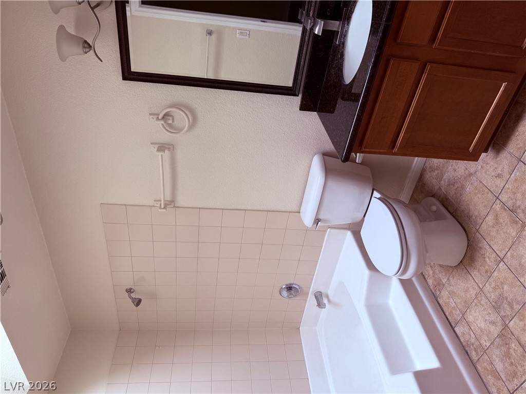 9325 West Desert Inn Road, Unit 260 Las Vegas, NV 89117 - Photo 14 of 42 Well-maintained bathroom featuring a practical shower-tub combination and dark granite vanity.