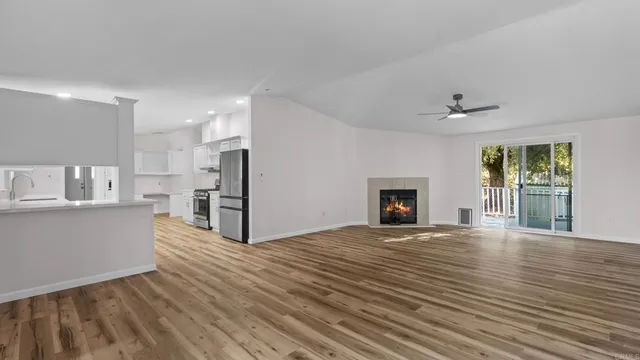 a view of a kitchen with wooden floor and a fireplace