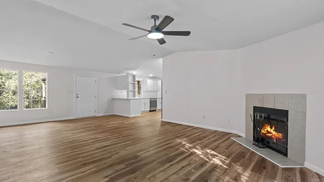 a view of empty room with wooden floor and fireplace