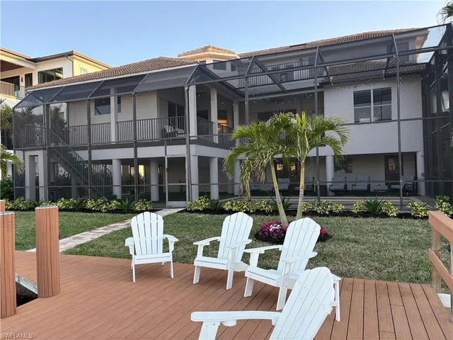 a view of a chair and table in backyard of the house