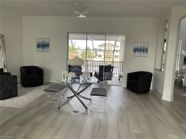 a living room with furniture a rug and a floor to ceiling window