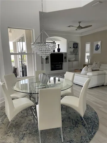 a living room with furniture a fireplace and a chandelier