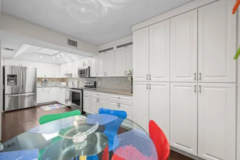 a kitchen with white cabinets and stainless steel appliances