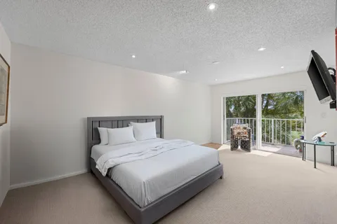 a large bedroom with a bed and large window
