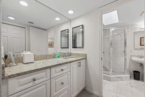 a bathroom with a bathtub shower sink mirror and toilet