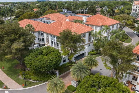 an aerial view of a house with swimming pool a yard and patio