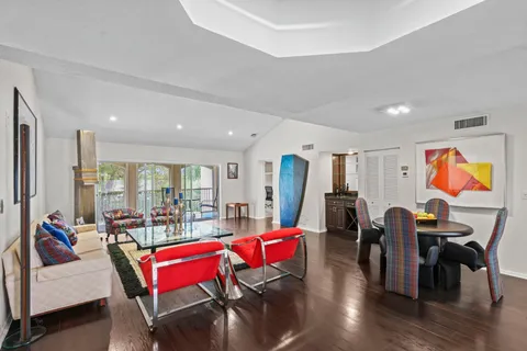 a living room with furniture a rug and kitchen view