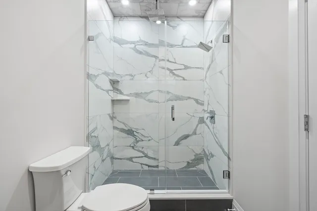 a bathroom with a toilet and a shower