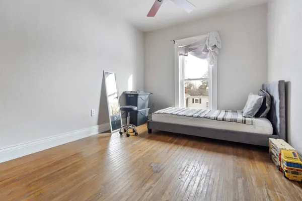 a bedroom with a bed and wooden floor