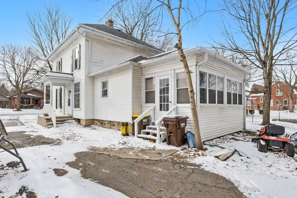 a view of a house with a yard covered in snow