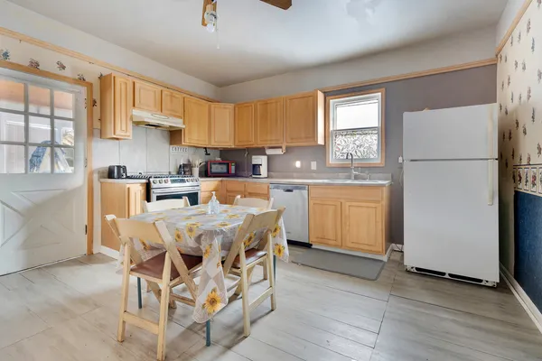 a kitchen with a table chairs refrigerator a sink dishwasher and cabinets
