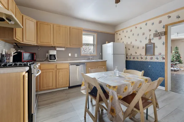 a kitchen with a table chairs refrigerator and cabinets