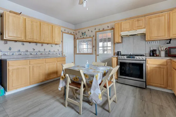 a kitchen with a stove a sink and wooden floor