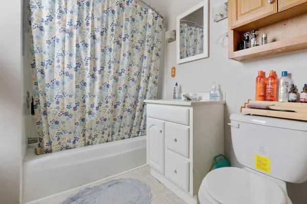 a bathroom with a toilet and a shower curtain