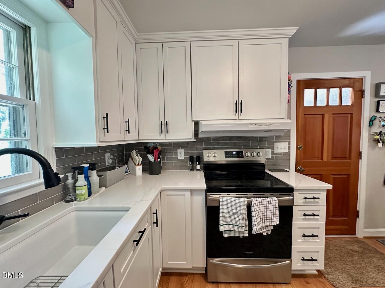 2813 Barmettler Street Raleigh, NC 27607 - Photo 10 of 22 a kitchen with stainless steel appliances granite countertop a stove a sink and a microwave