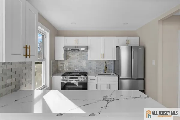 a kitchen with white cabinets and stainless steel appliances