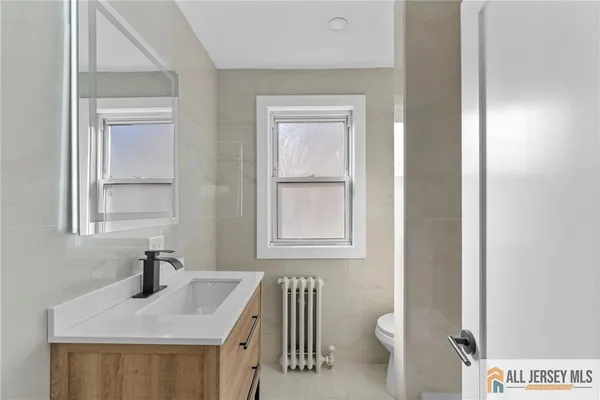 a bathroom with a sink a toilet and a mirror