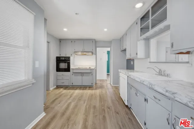 a large kitchen with a large counter top appliances and cabinets
