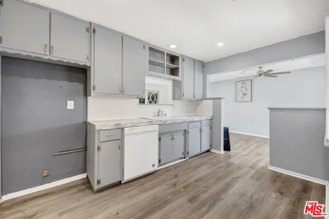 a kitchen with a sink cabinets and wooden floor