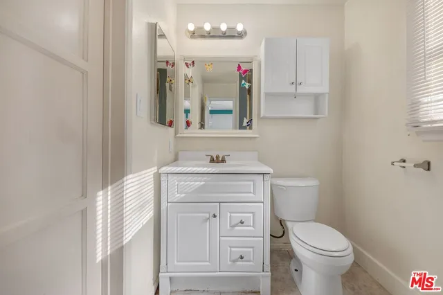 a bathroom with a toilet sink and mirror