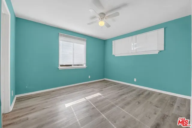 an empty room with closet and windows