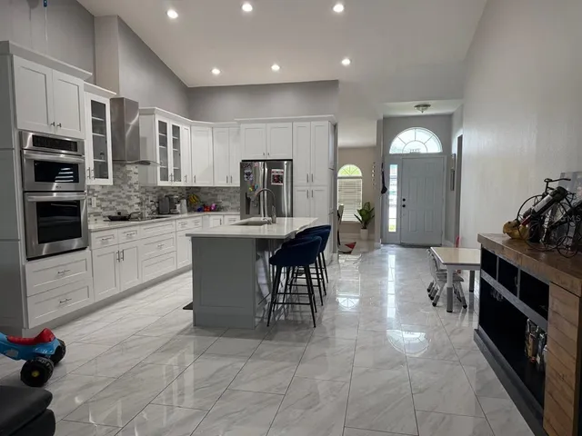 a kitchen with kitchen island granite countertop lots of counter top space appliances and cabinets