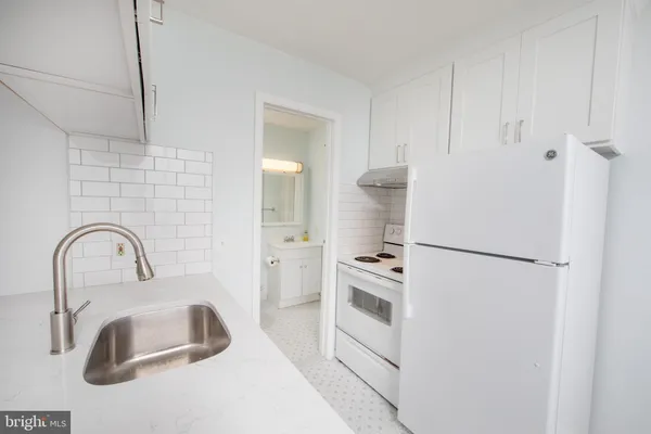 a close view of a sink and a refrigerator in a kitchen
