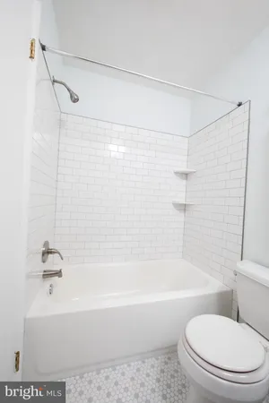 a bathroom with a shower a toilet and a bathtub