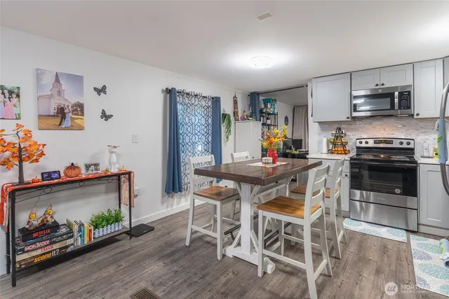 a kitchen with stainless steel appliances a stove a sink dishwasher and cabinets with wooden floor