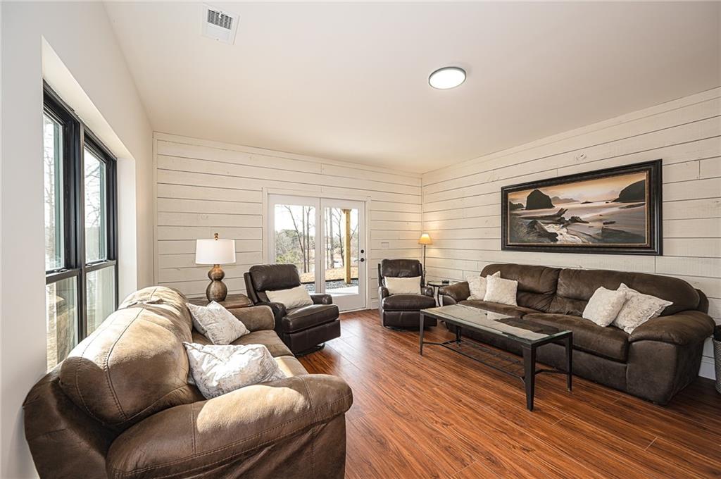 3339 Cove Overlook Road Gainesville, GA 30501 - Photo 29 of 67 a living room with furniture two windows and a wooden floor
