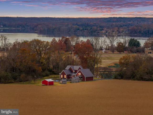 a front view of a house with a yard and lake view