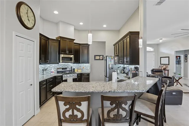 a kitchen with stainless steel appliances granite countertop a stove refrigerator and cabinets
