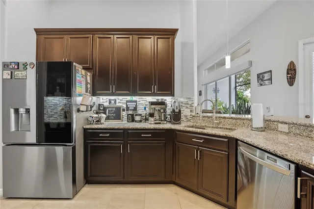 a kitchen with stainless steel appliances granite countertop a stove a sink and a refrigerator