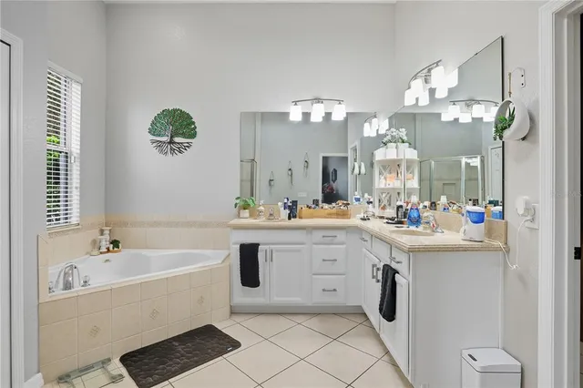 a large white bathroom with a sink a large mirror and a bathtub