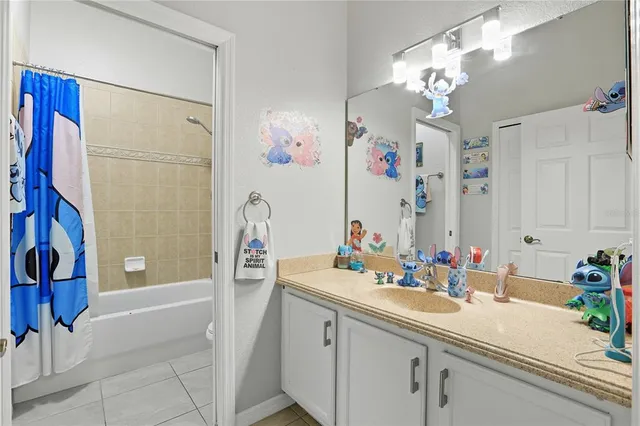 a bathroom with a sink vanity granite tub shower and a mirror