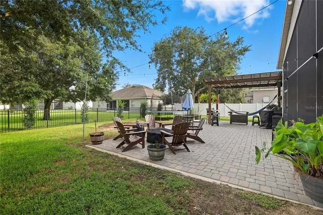a view of a patio with table and chairs potted plants and large tree