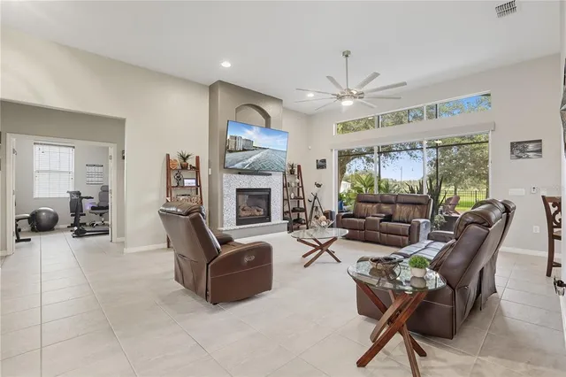 a living room with furniture a fireplace and a large window