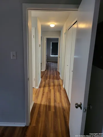 wooden floor with a view of a bathroom