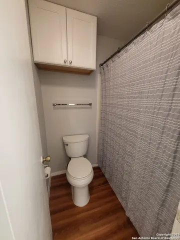 a bathroom with a toilet and a mirror