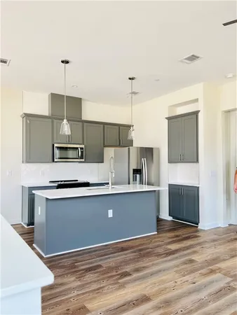 a kitchen with stainless steel appliances a sink a table and chairs