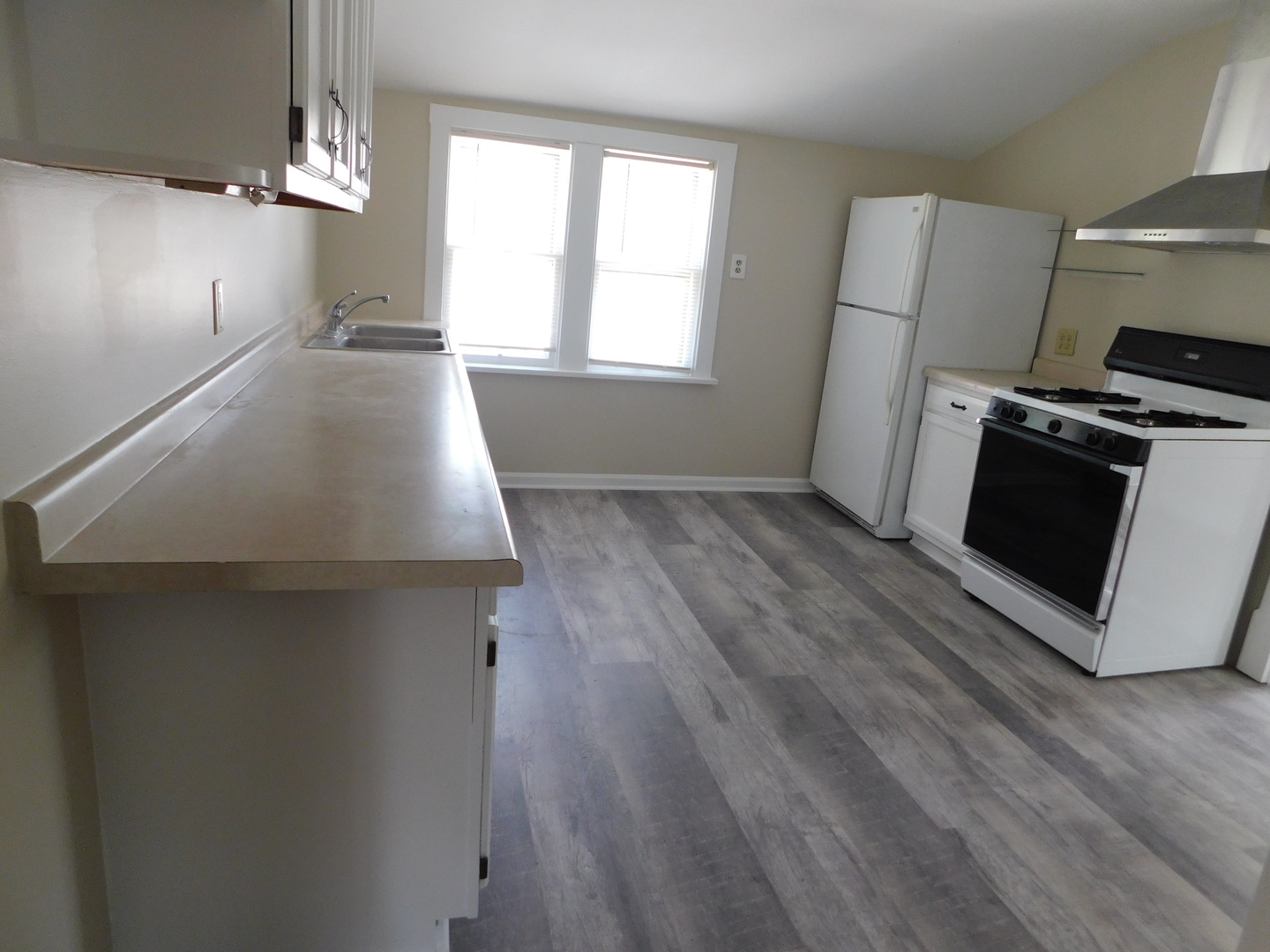 307 South Main Street Algonquin, IL 60102 - Photo 3 of 15 an empty room with wooden floor a sink and a stove top oven